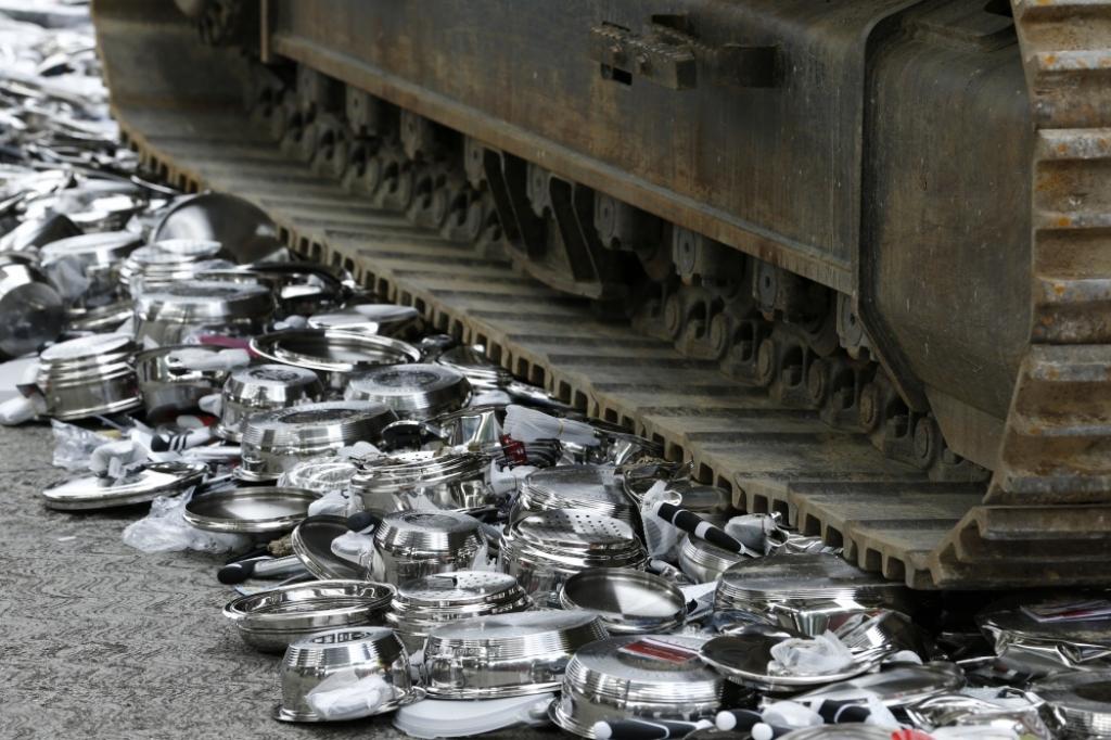 FOTO: Buldozers iznīcina viltotus katlus un pannas